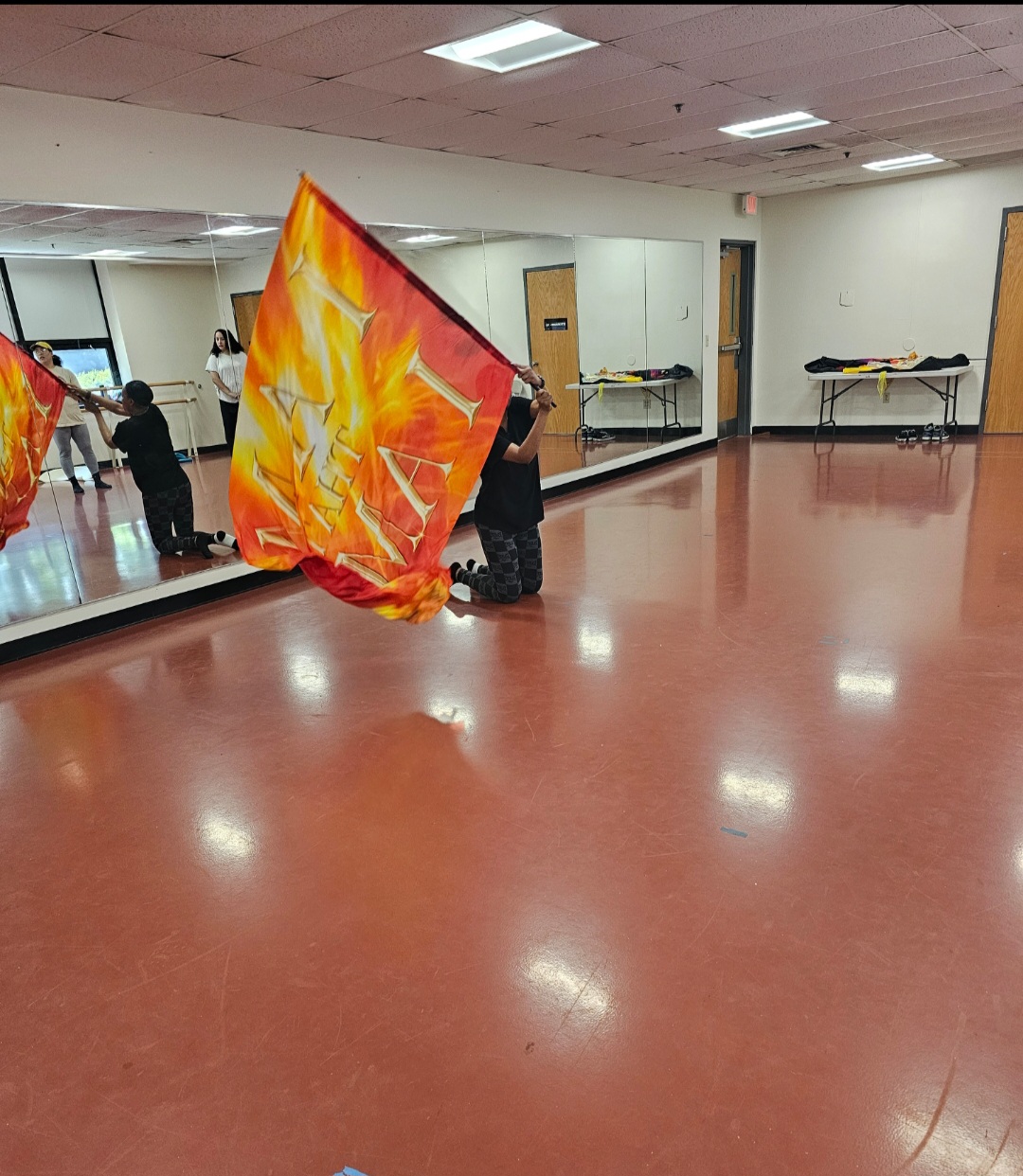 Student worshiping with a flame-colored flag during studio training