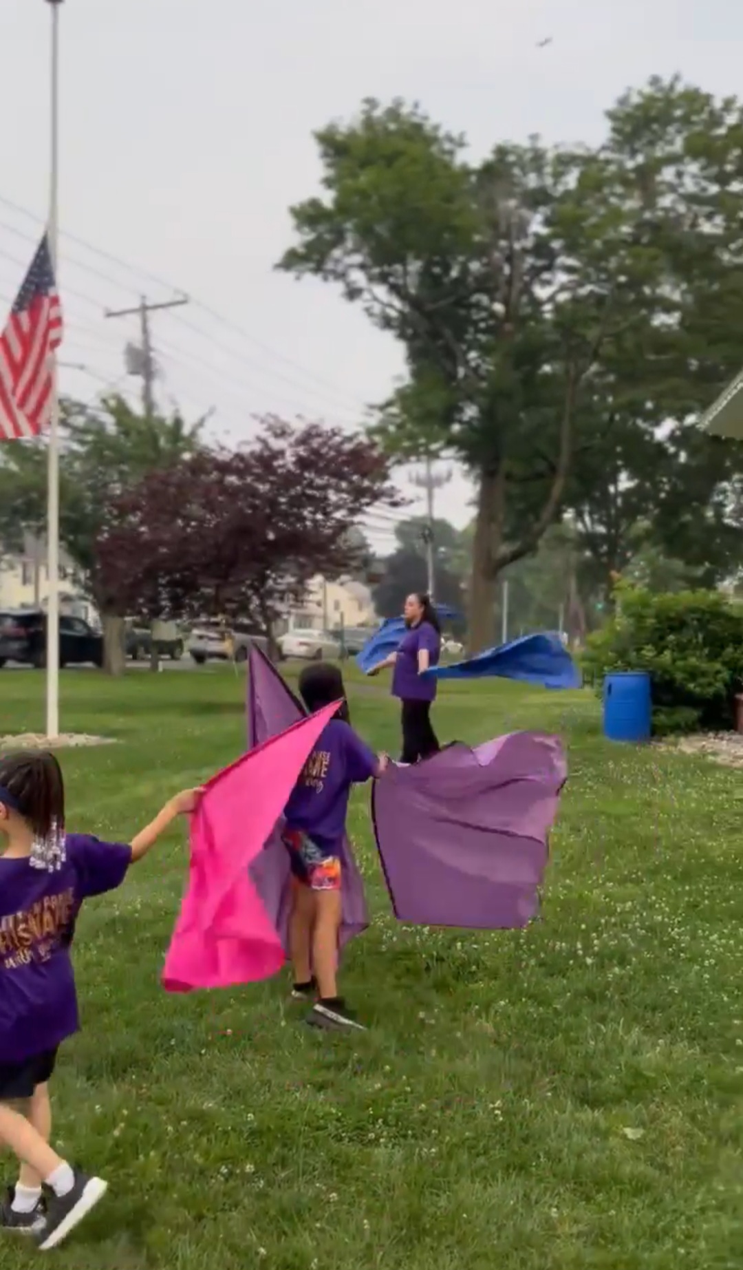 Children and instructor flagging together on the grass outdoors