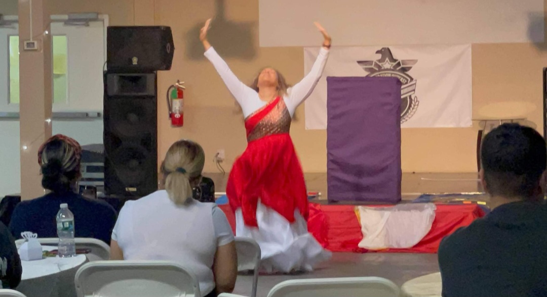 Worshipper in red and white ministering in praise dance at a gathering