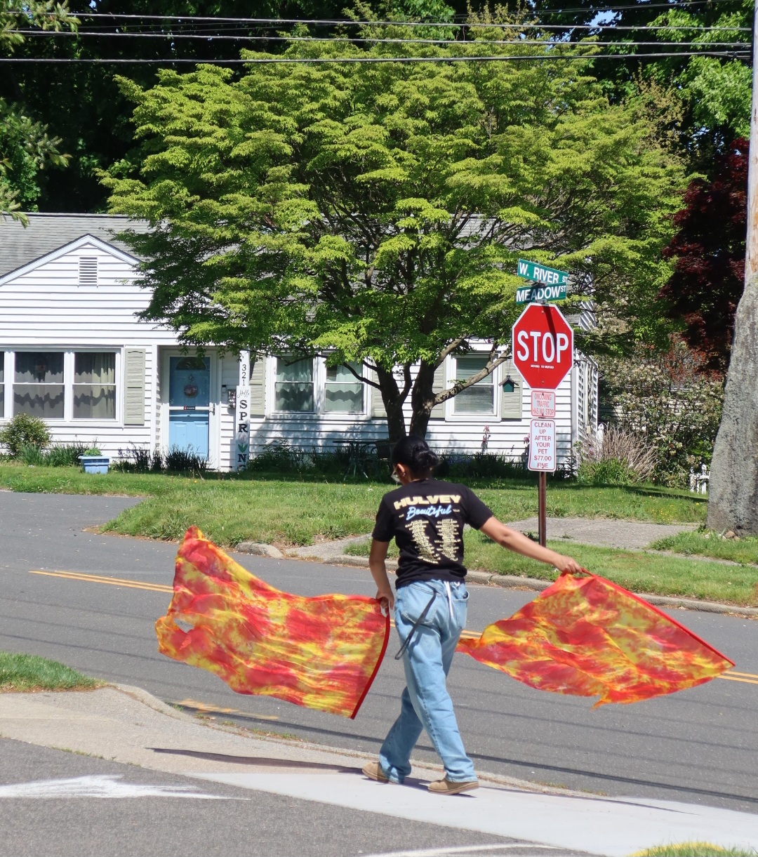 Worshipper carrying flame-colored flags through the neighborhood in outreach