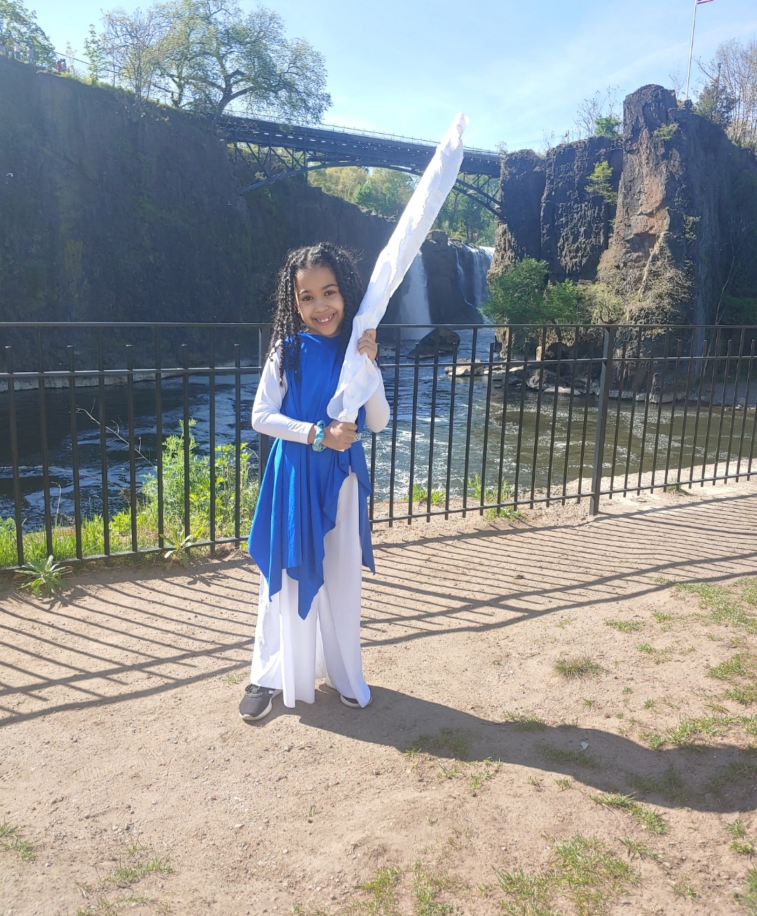 Young worshipper holding a white flag by the waterfalls
